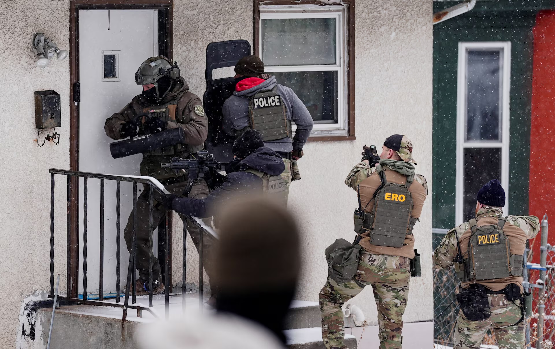 law enforcement officer uses a battering ram to force entry into a home during an immigration raid in St. Paul, Minnesota, U.S., days after an ICE agent fatally shot Renee Nicole Good, January 18, 2026. REUTERS/Leah Millis